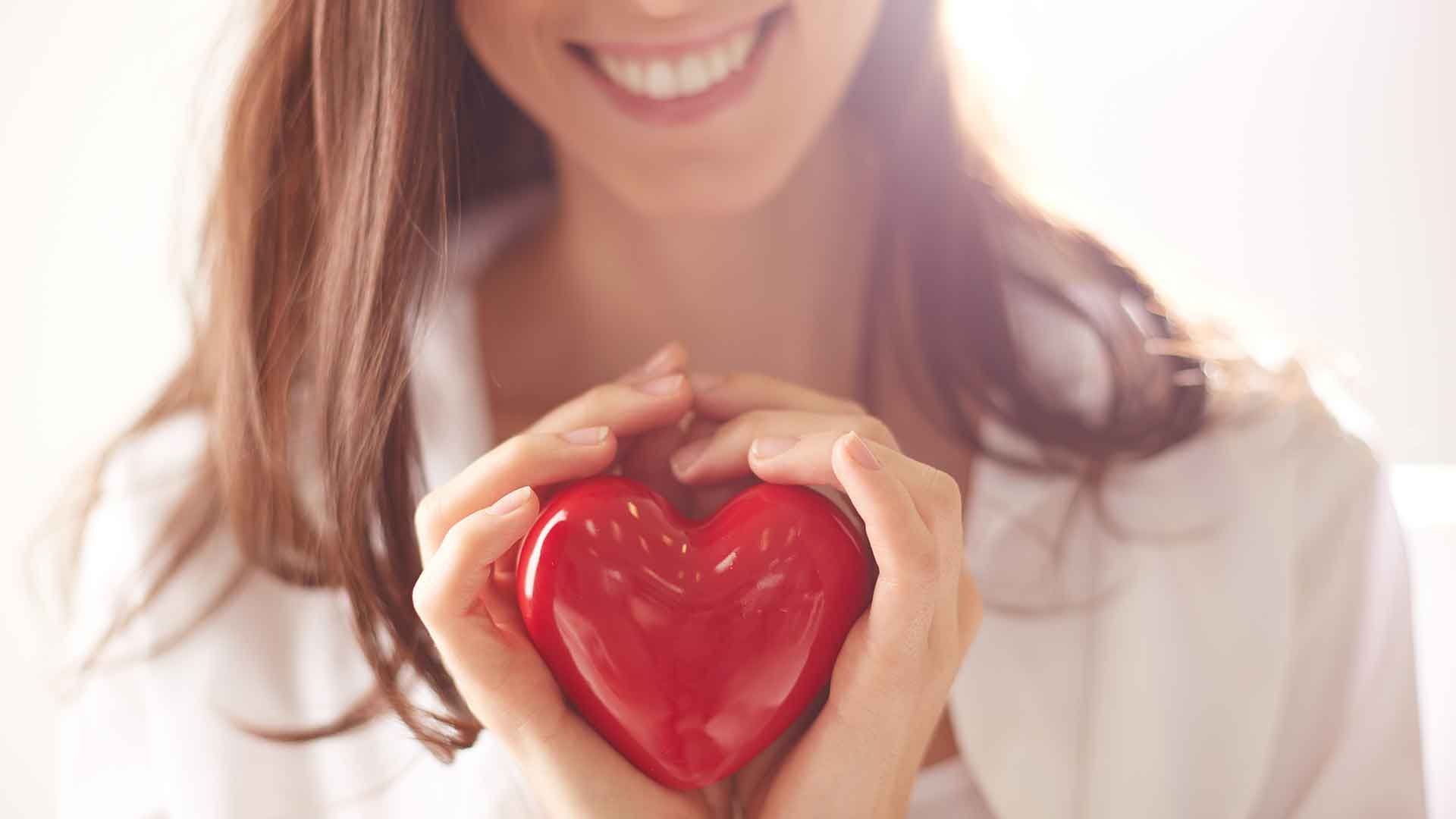 Mujer con un corazón de plástico en las manos